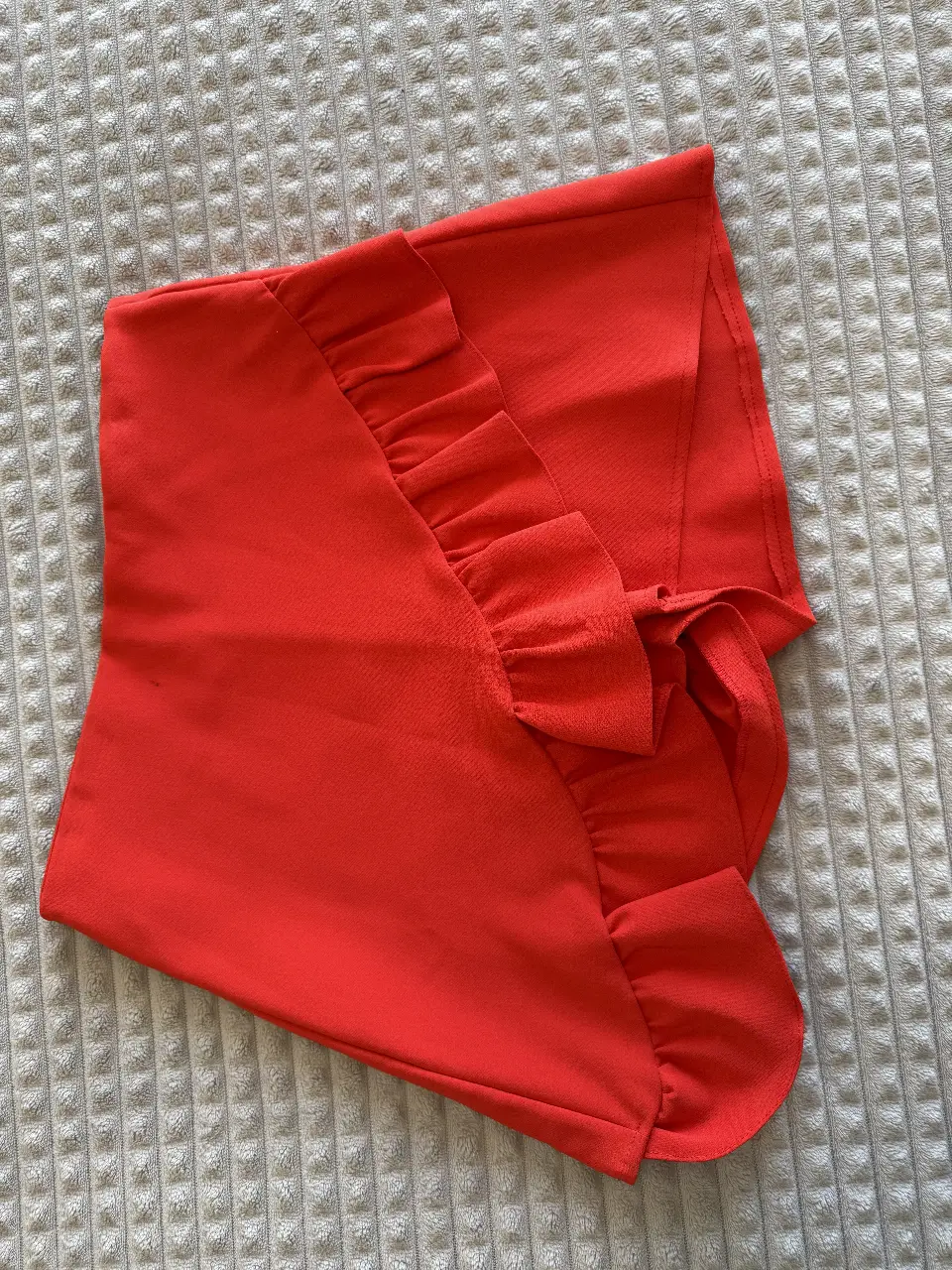 Pollera sastrera roja con volados y detalle de lazo. Ideal para un look elegante y moderno.