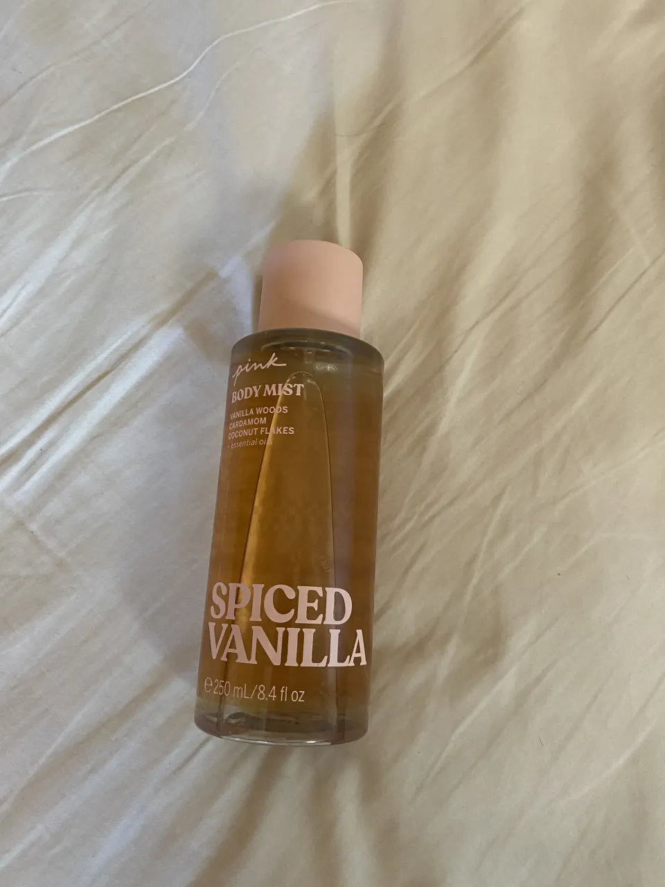 Body mist "Spiced Vanilla" de Pink. Contiene notas de vainilla, woods, cardamamom y coconut flakes. Presentación de 250 ml.
