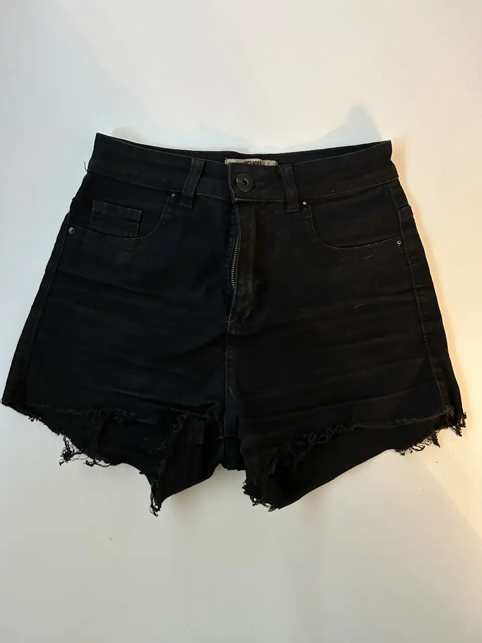 Short de jean negro Peuque con detalles desflecados en el borde. Tiro alto.