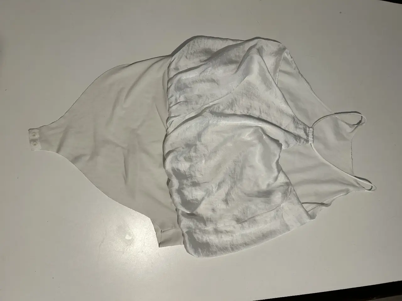 Body blanco de mujer, con diseño de cuello halter y espalda descubierta. Ideal para un look elegante y moderno.