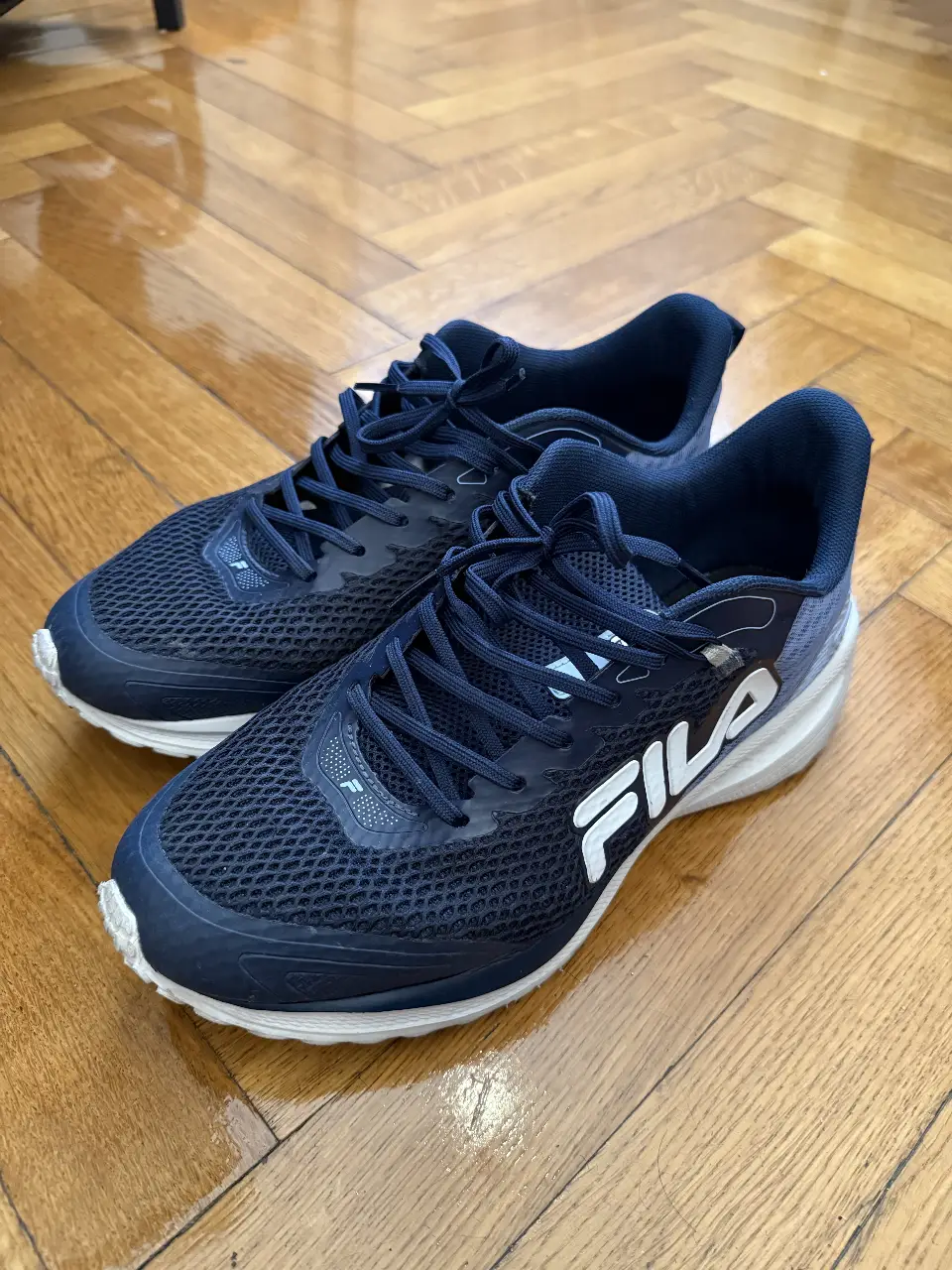 Zapatillas Fila azules para hombre, ideales para running y entrenamiento. Diseño moderno y cómodo, con suela blanca y detalles en blanco. Perfectas para tus actividades deportivas.