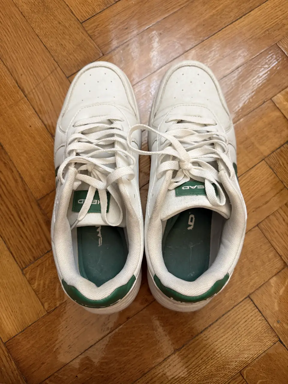 Zapatillas blancas de la marca Head con detalles en verde. Ideales para un look casual y deportivo.