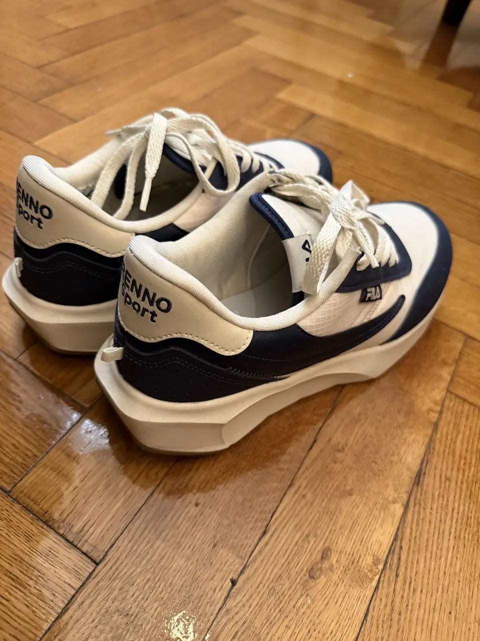 Zapatillas Fila blancas con detalles en azul. Ideales para un look casual y deportivo.