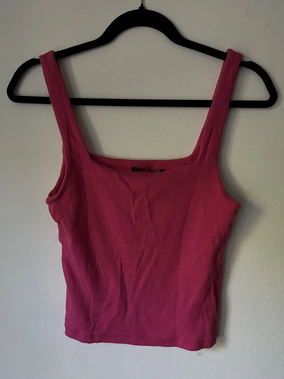 Musculosa rosa con breteles anchos y escote cuadrado.