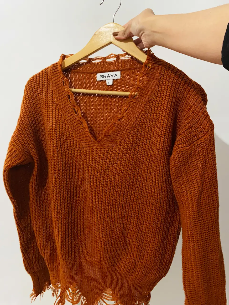 Sweater tejido en V color ocre con detalles desflecados en el cuello y en el borde inferior. Talle pequeño S/M