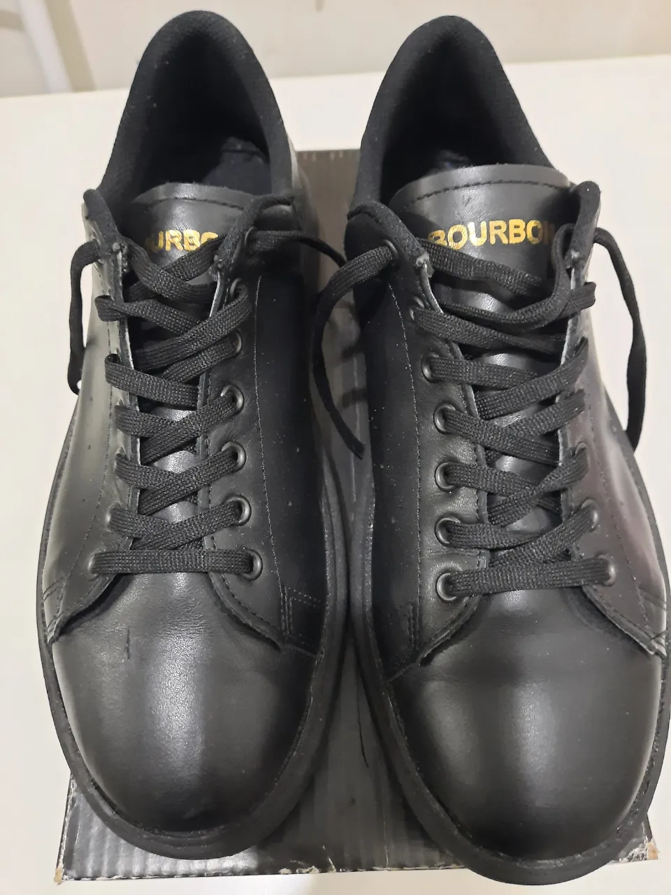 Zapatillas negras de hombre, estilo urbano, con cordones y suela gruesa. Ideales para un look casual y moderno.
