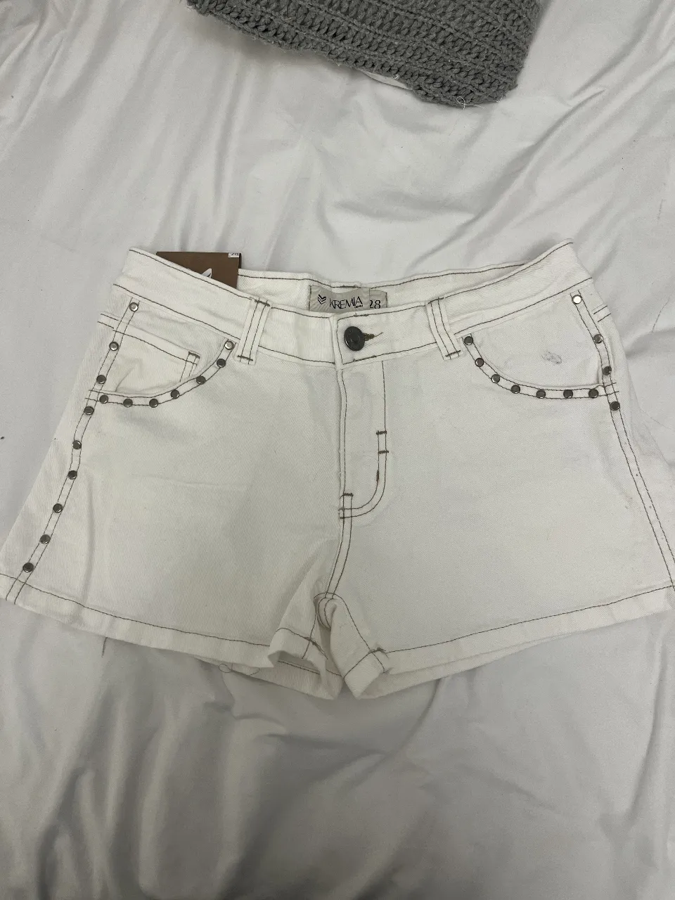 Shorts de jean blanco elastizado con tachas y pespuntes a tono. Un básico canchero para armar looks de verano.