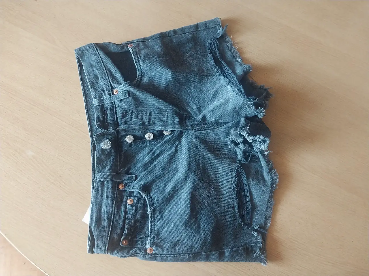 Short de jean de hombre, tiro medio, con detalles de roturas y desgaste. Marca Levi's.