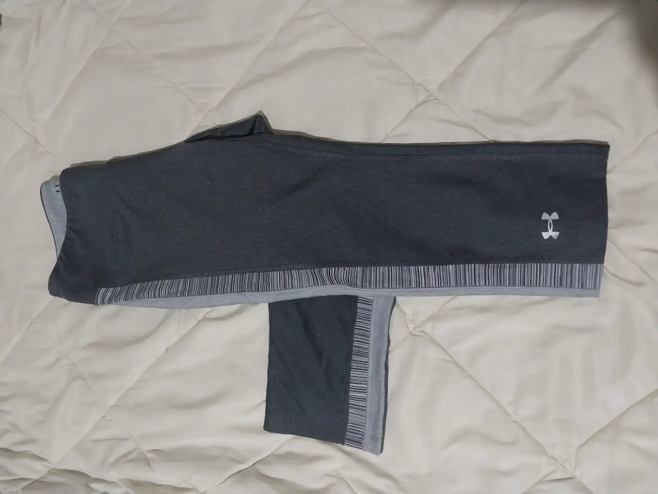 Pantalón deportivo de mujer Under Armour, color gris, talle S/P, corte ajustado, ideal para actividades físicas y uso casual. Confeccionado con tejido HeatGear para mayor comodidad y rendimiento. talle s