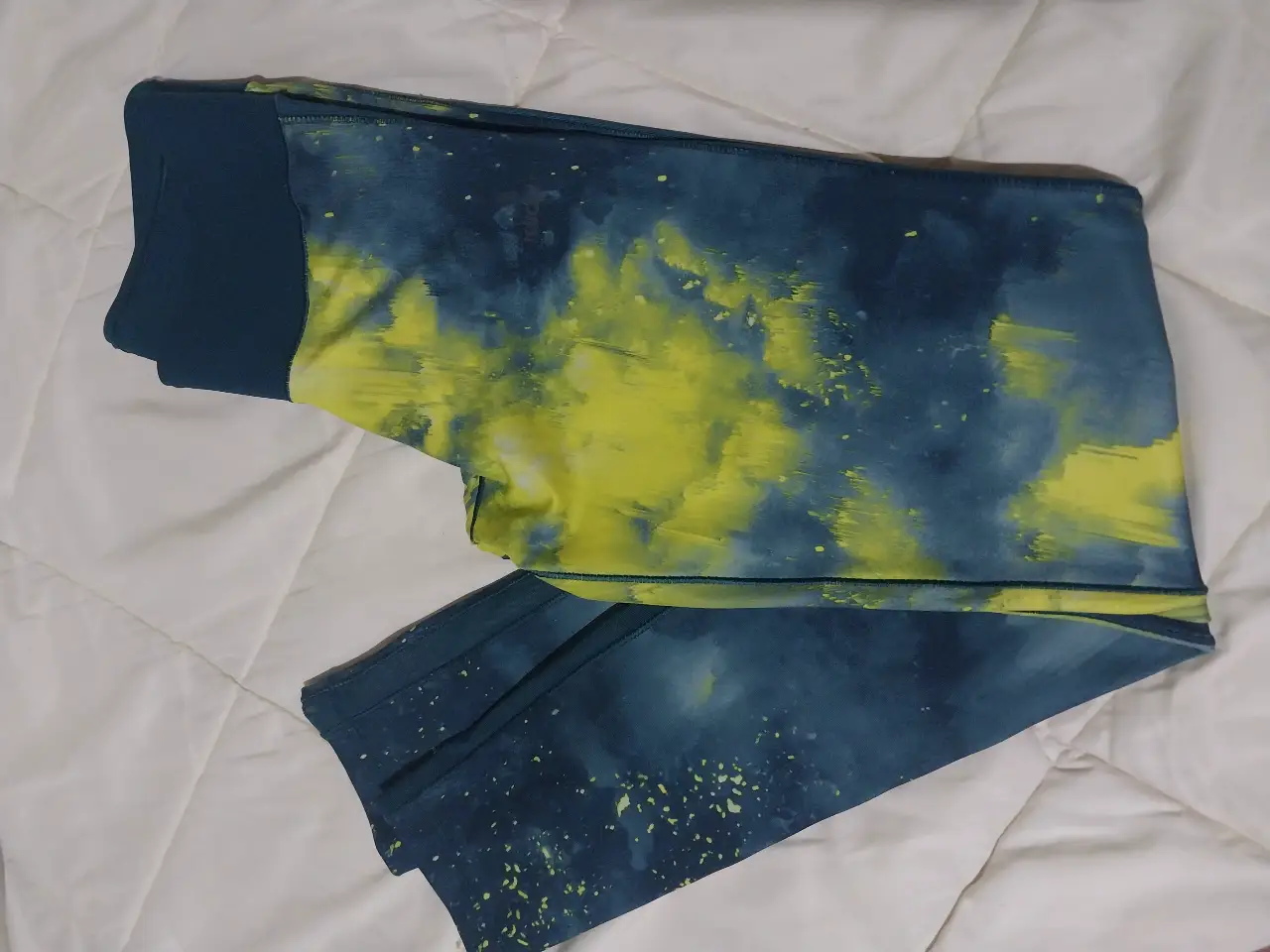 Calzas deportivas Adidas Climalite con estampado abstracto en tonos azul y amarillo. Ideal para entrenamientos y actividades físicas.