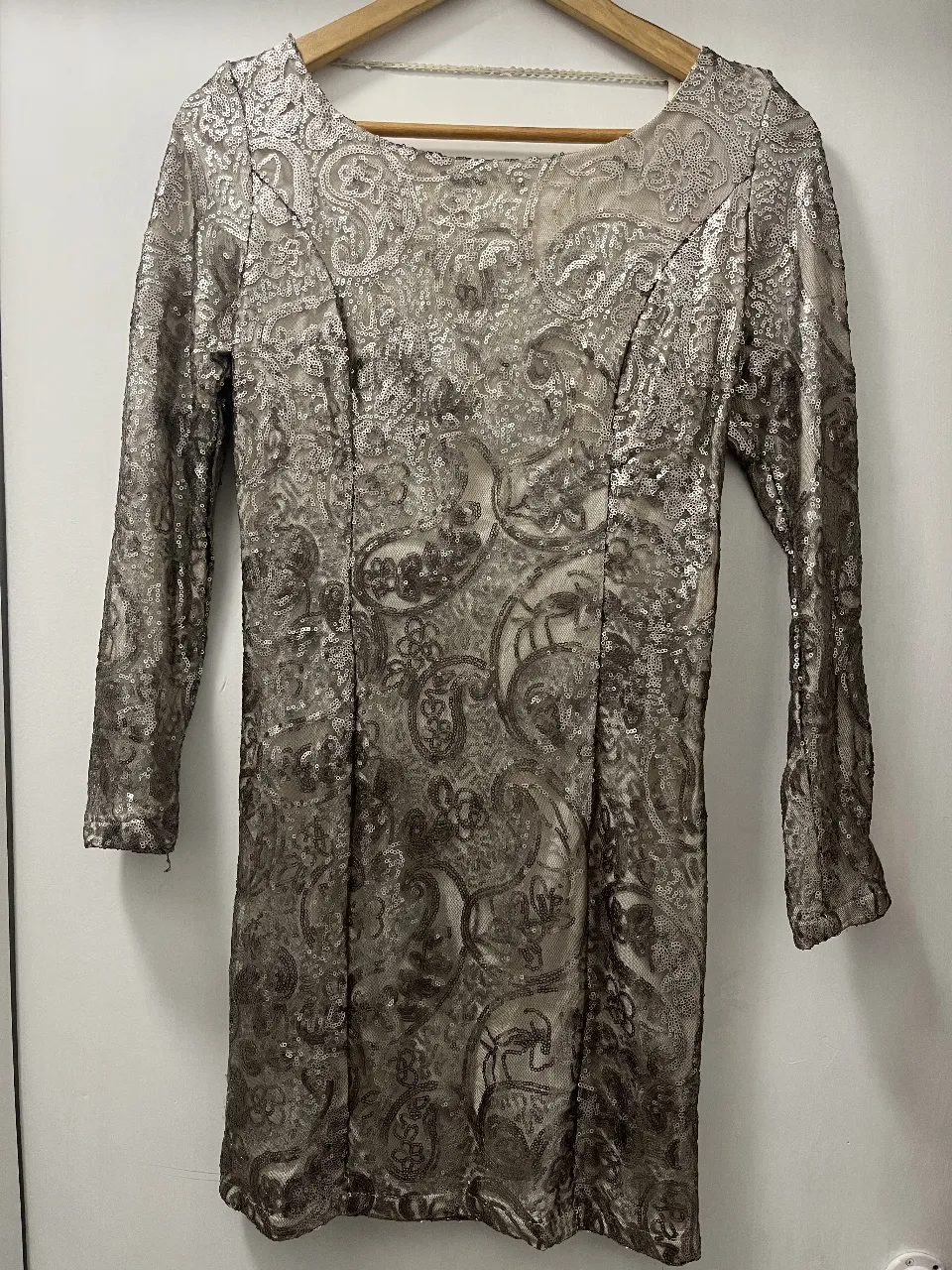 Vestido largo plateado con lentejuelas y escote profundo en la espalda. Ideal para fiestas y eventos especiales. Su diseño brillante y elegante te hará destacar.