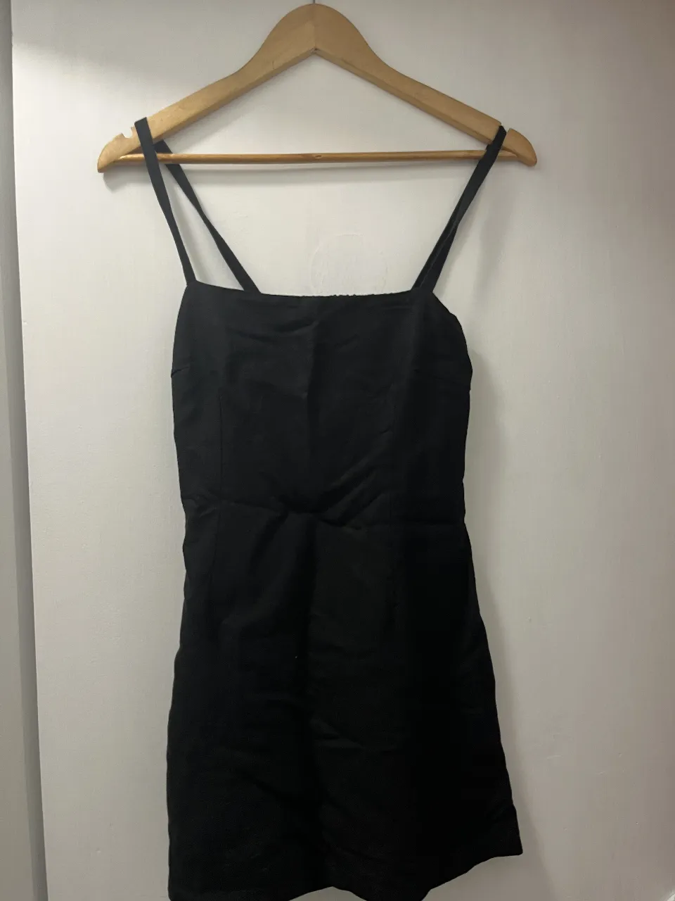 Vestido negro corto con tiras finas y espalda descubierta. Ideal para salidas nocturnas o eventos informales.