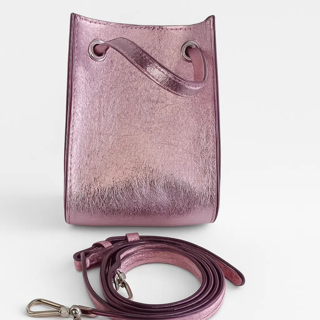 Cartera tipo bucket bag en color rosa metalizado. Incluye correa para llevar al hombro o cruzada.