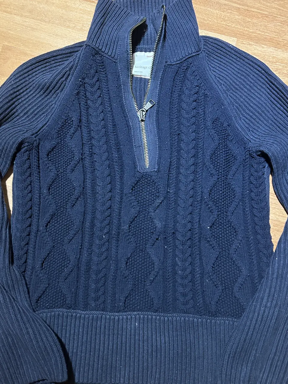 Sweater de hombre azul marino de la marca Banana Republic, de la colección Heritage. Con cierre en el cuello y diseño tejido.