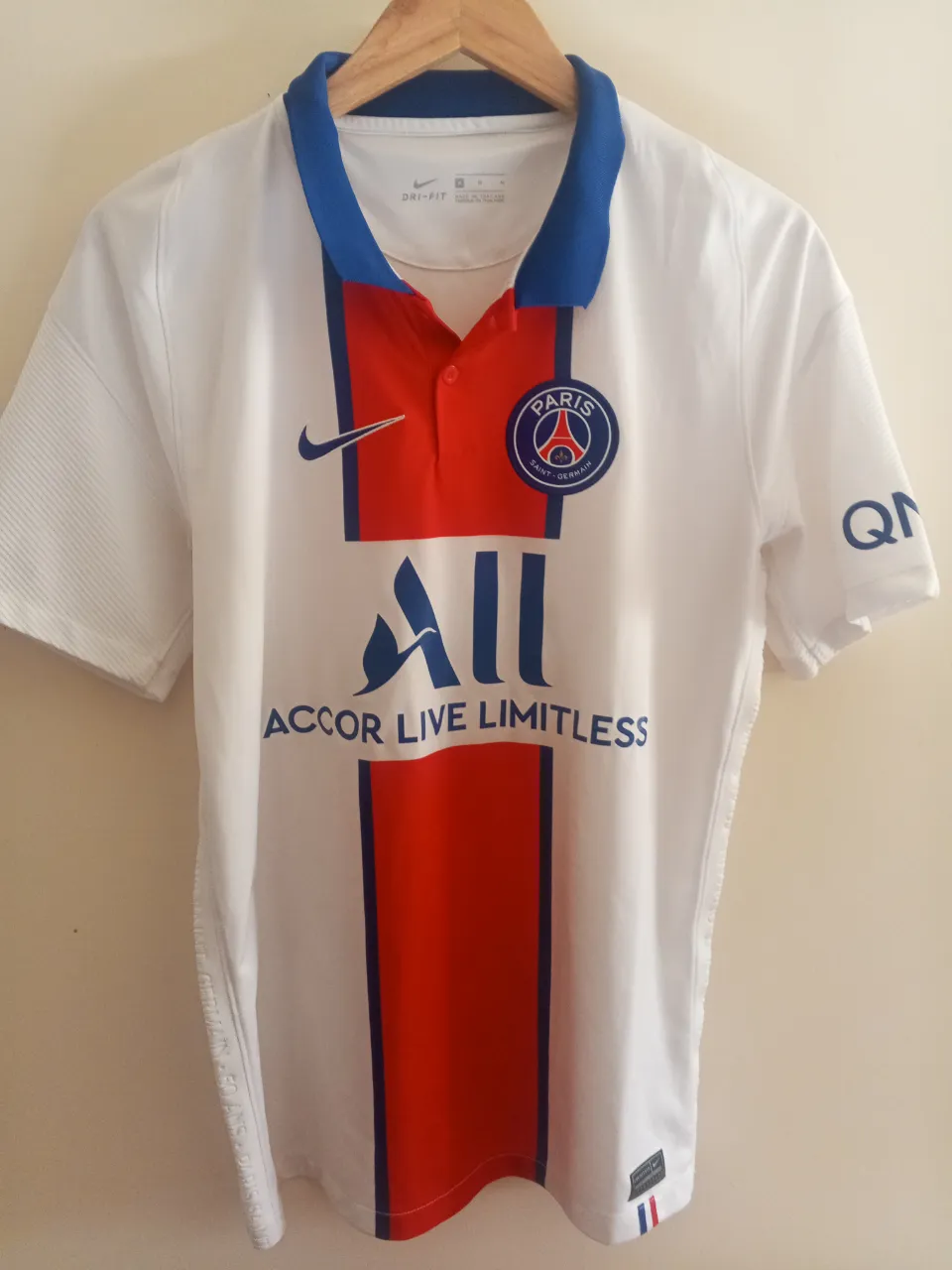 Camiseta de fútbol del Paris Saint-Germain (PSG) para hombre. Diseño clásico con los colores del equipo, blanco con una franja roja central y detalles en azul. Ideal para fanáticos y coleccionistas.