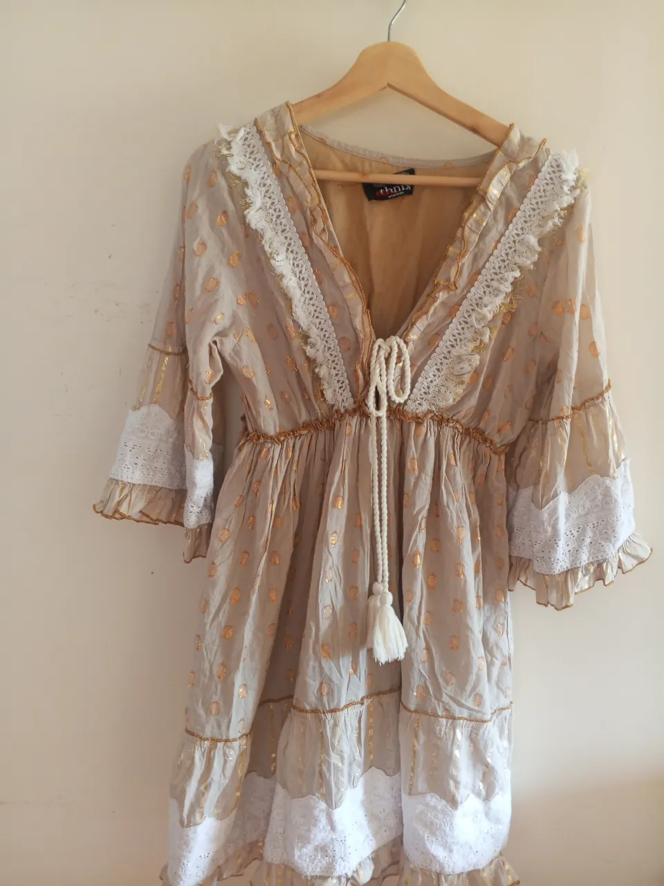 Vestido midi estilo boho, con detalles dorados y encaje blanco. Ideal para un look casual y con un toque vintage.