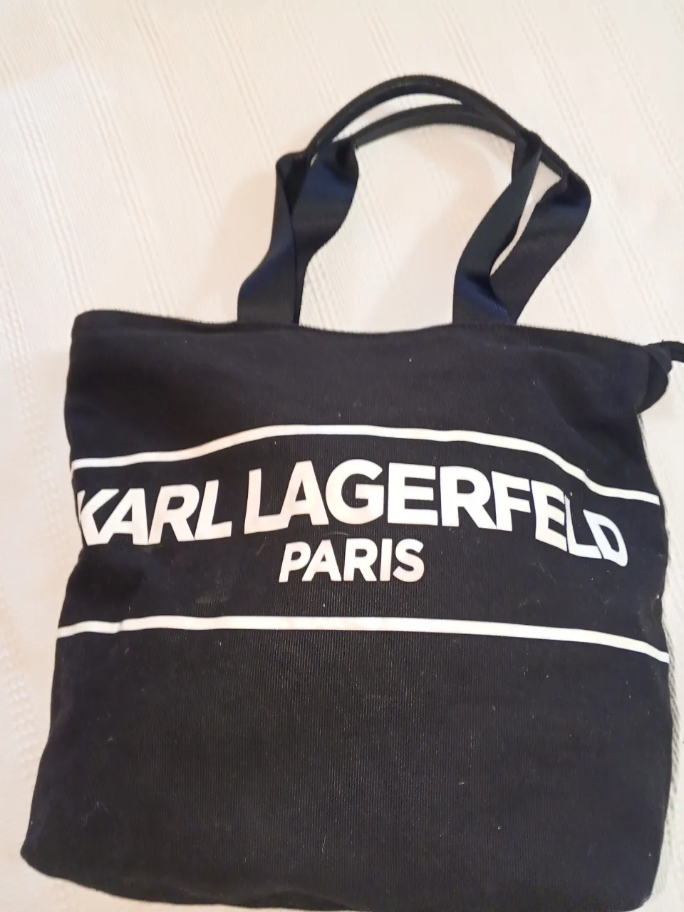 Bolso tote negro de tela con el logo KARL LAGERFELD PARIS en blanco. Ideal para llevar tus cosas con estilo.