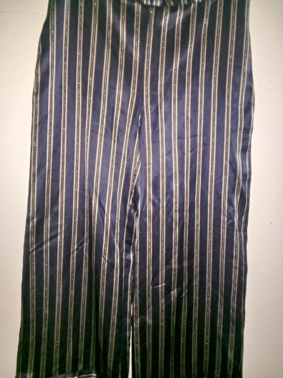 Pantalón sastrero de mujer con rayas verticales en tonos azul marino y dorado. Corte recto y elegante, ideal para un look sofisticado.
