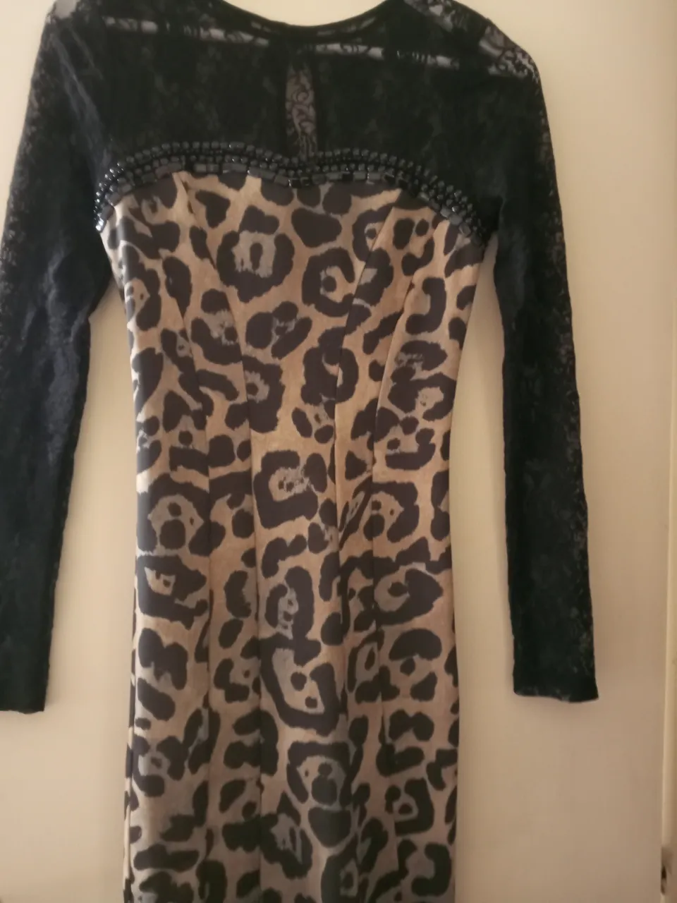 Vestido midi para mujer con estampado de leopardo y mangas largas de encaje negro. Detalles de pedrería en el escote. Ideal para fiestas y salidas.