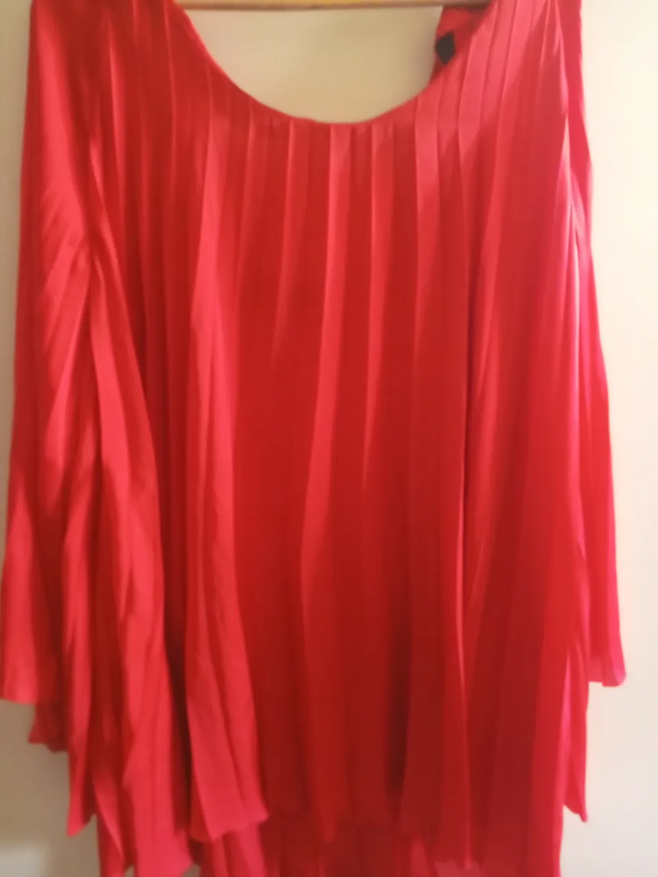 Blusa roja con mangas amplias y plisado. Ideal para un look elegante y sofisticado.