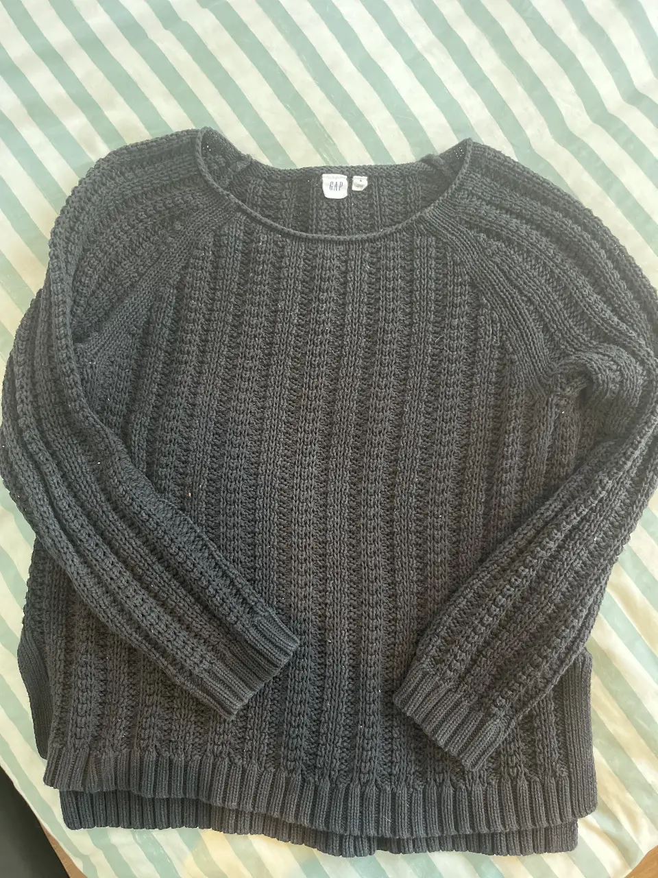 Sweater largo de mujer, color gris oscuro, de la marca GAP. Tejido grueso con detalles acanalados en el cuerpo y mangas. Cuello redondo y mangas largas. Ideal para un look casual y abrigado.