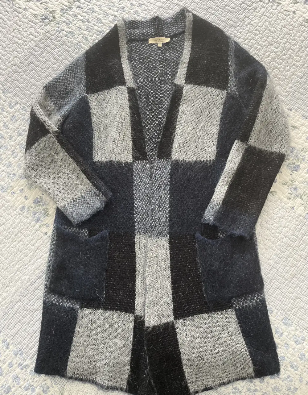 Cardigan largo de mujer con diseño a cuadros en tonos grises y negros. Ideal para un look casual y abrigado.