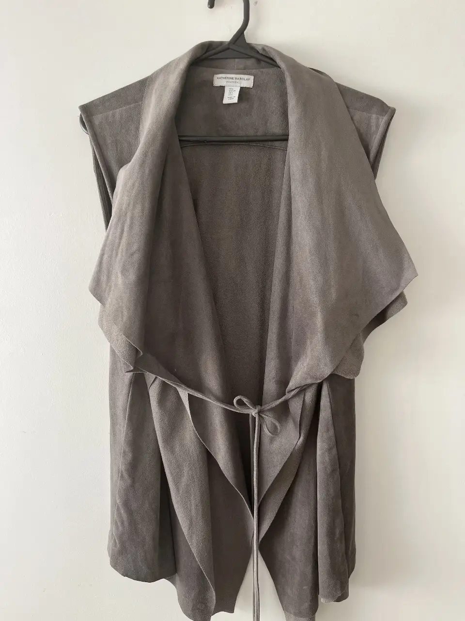 Chaleco de gamuza sintética gris, con diseño de solapa y lazo en la cintura. Ideal para un look casual y elegante.