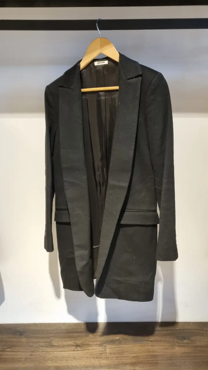 Elegante tapado negro de Etiqueta Negra, ideal para un look formal o de trabajo. Confeccionado en paño de alta calidad, este blazer ofrece un ajuste impecable y un estilo atemporal. Perfecto para combinar con pantalones sastreros o jeans.