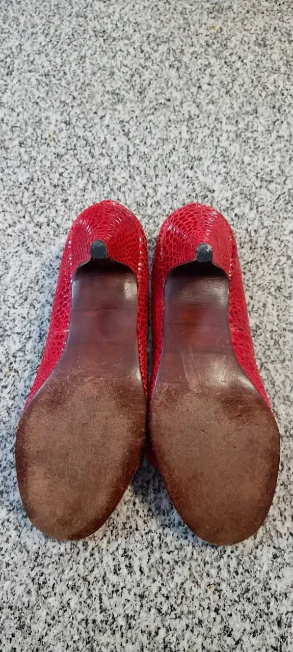 Zapatos de taco alto rojos con detalle de flor en la punta. Ideales para una fiesta o evento especial.