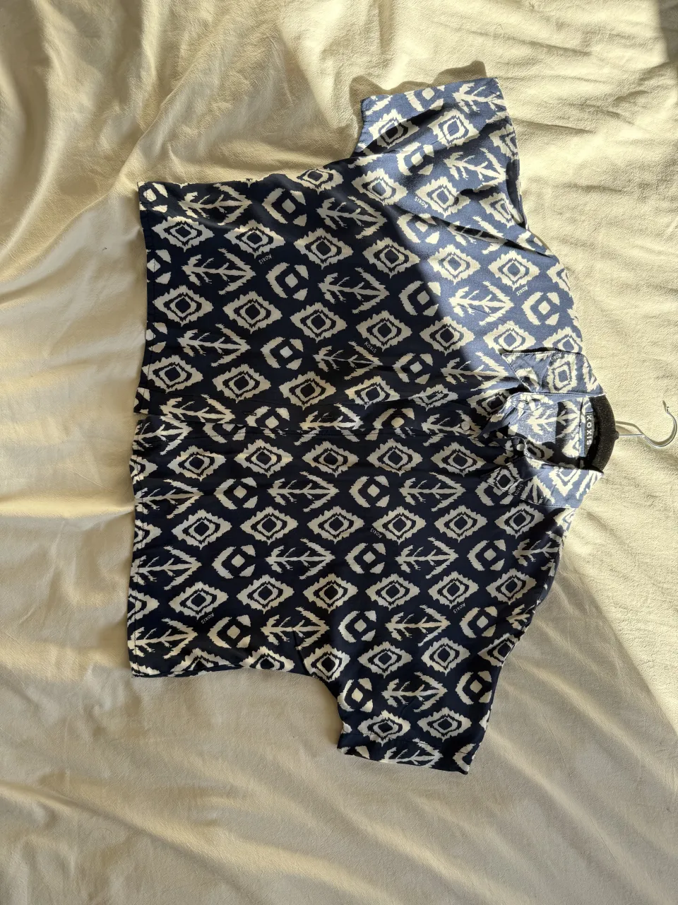 Remera estampada con motivos geométricos en azul y blanco. Ideal para un look casual y fresco.