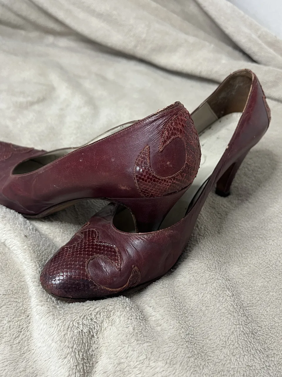 Zapatos de taco alto color bordó, con detalles de textura tipo serpiente en la punta y el talón. Un clásico que nunca pasa de moda, ideal para complementar looks elegantes y sofisticados. Perfectos para una salida o evento especial.