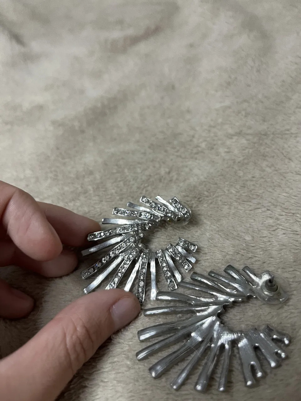 Aros plateados con diseño de abanico y detalles de strass. Ideales para darle un toque de brillo a cualquier look.