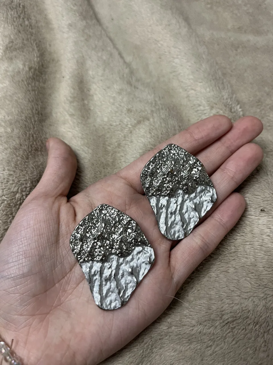 Aros plateados con un diseño único y texturizado, perfectos para darle un toque especial a cualquier look. Su estilo moderno y llamativo los convierte en el accesorio ideal para destacar.