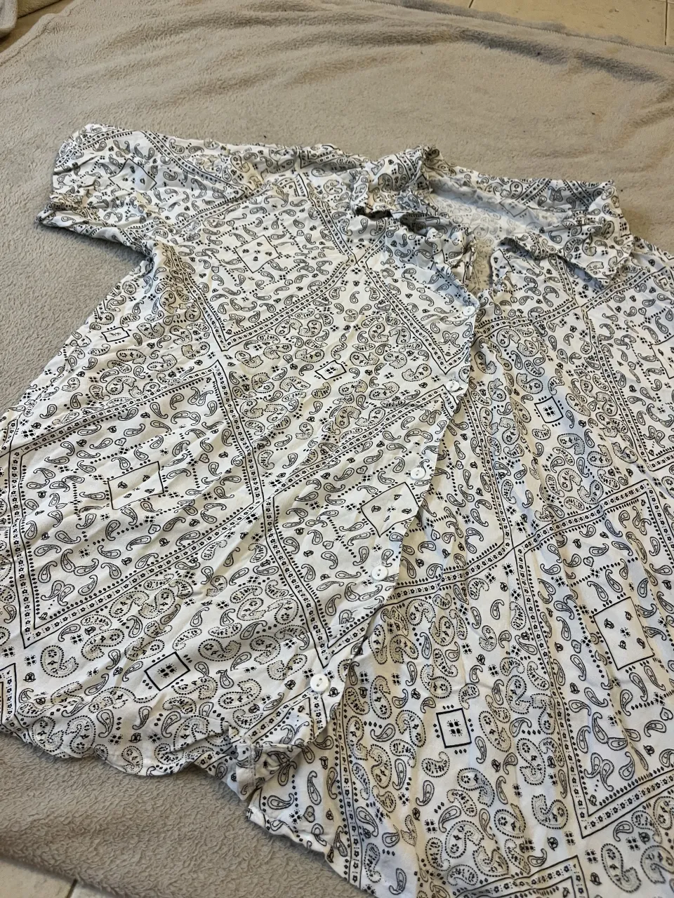 Camisa estampada con cuello y botones al frente. Diseño de pañuelo en blanco y negro.