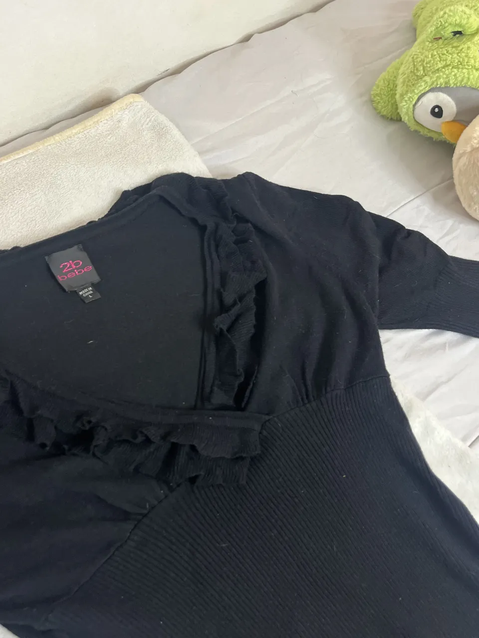 Remera negra manga larga con detalles de volados en el escote y cintura ajustada. Ideal para un look canchero y femenino.