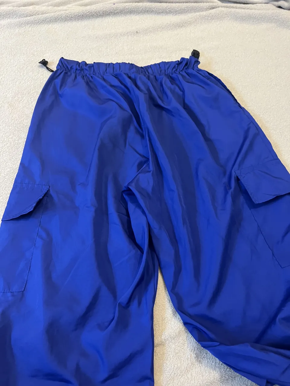 Pantalón cargo de color azul con cintura elastizada y cordón ajustable. Posee bolsillos cargo a los costados.