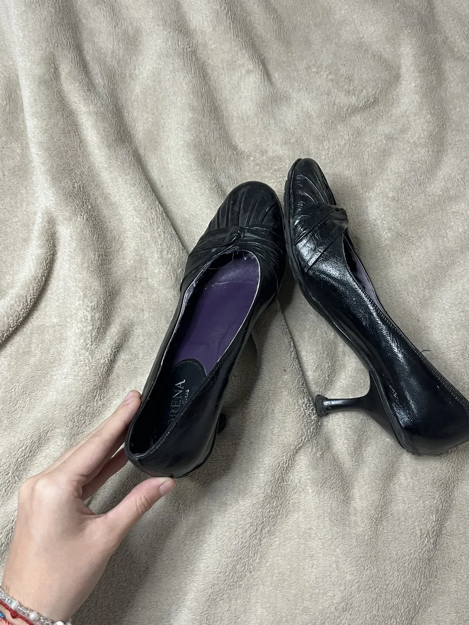 Zapatos de taco alto negros, con detalle de moño y fruncido en la punta. Ideales para un look elegante y sofisticado.