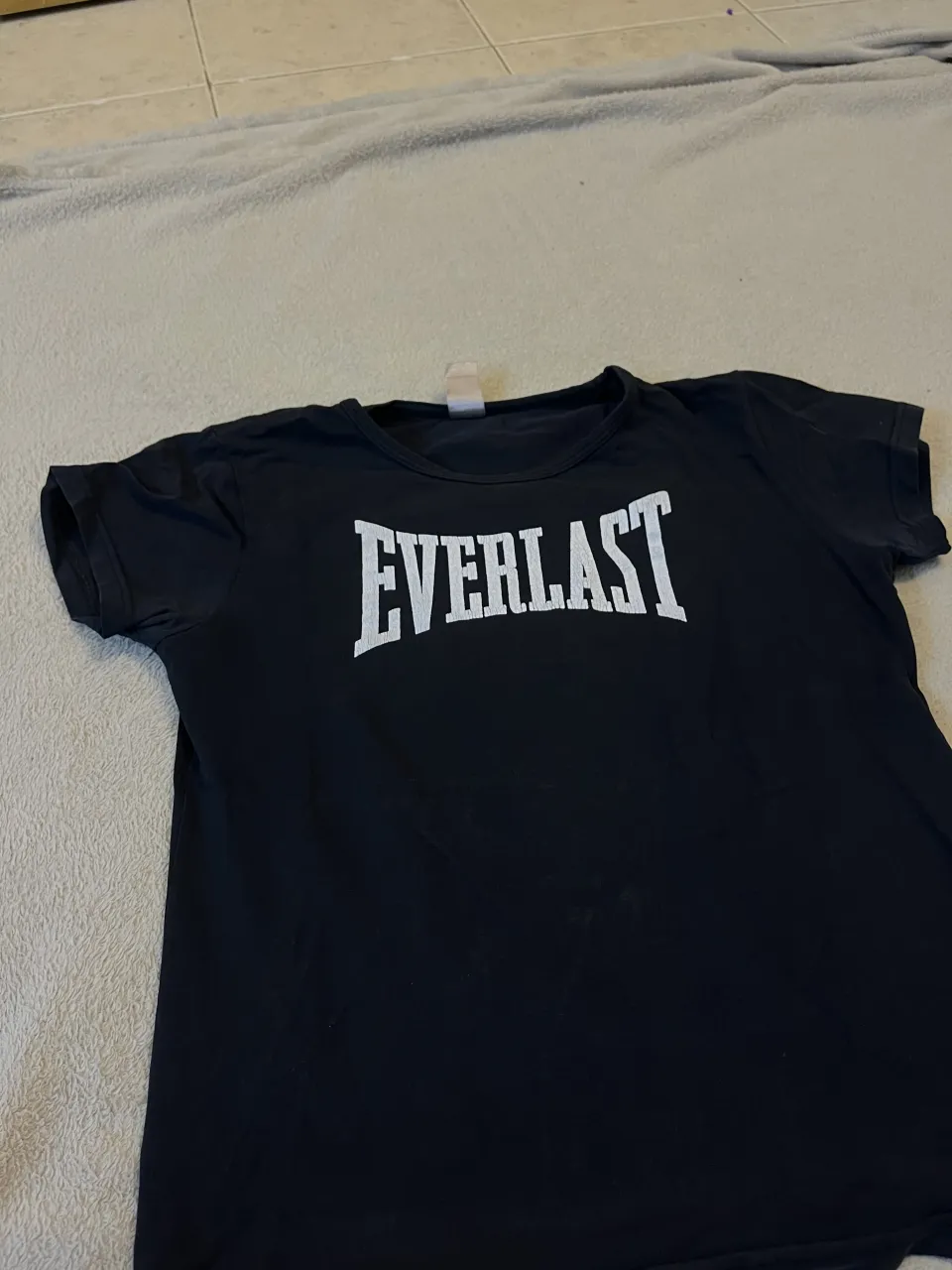 Remera negra de manga corta con logo de Everlast blanco en el frente. En la remera dice que es talle “xl” pero es mas como un M
