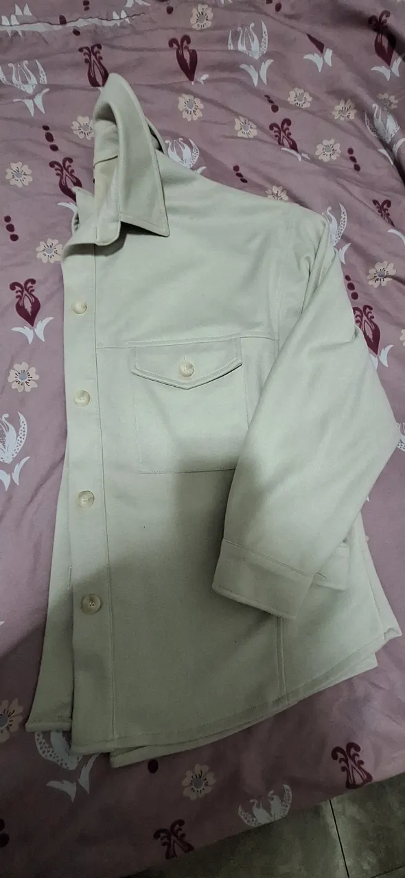 Camisa de mujer en color crudo, con dos bolsillos delanteros y botones. Ideal para un look casual y versátil.