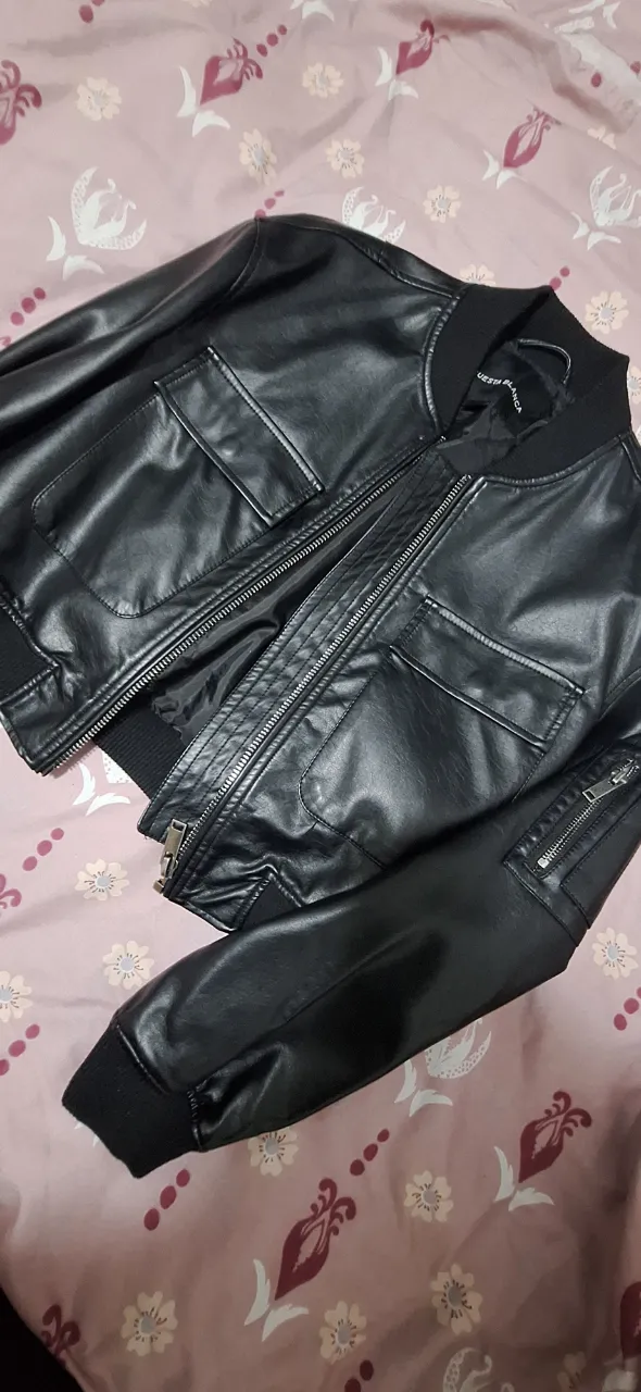 Campera bomber de cuero sintético negra, con bolsillos y cierre frontal. Ideal para un look casual y moderno.