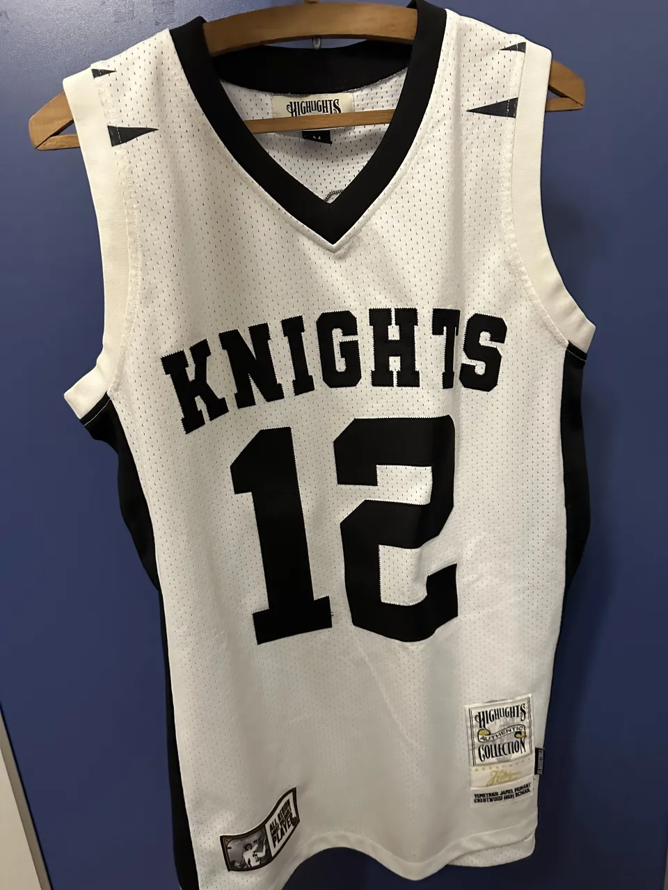 Remera deportiva blanca con detalles en negro, número 12 y la palabra "KNIGHTS" en el frente. En la espalda, el número 12 y la palabra "MORANT".