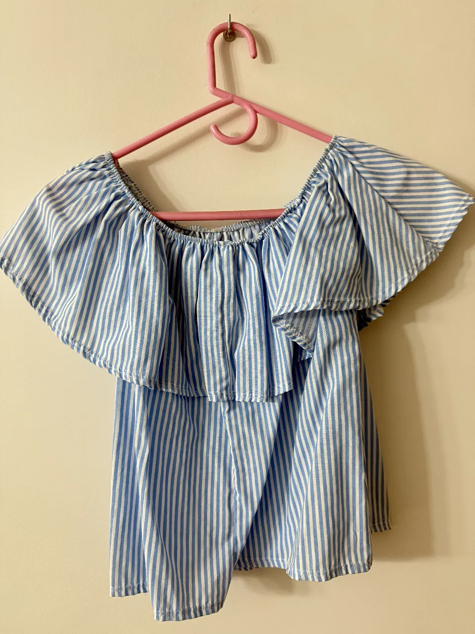 Blusa de mujer a rayas celeste y blancas, con volados en los hombros y corte off-shoulder. Ideal para un look fresco y casual.