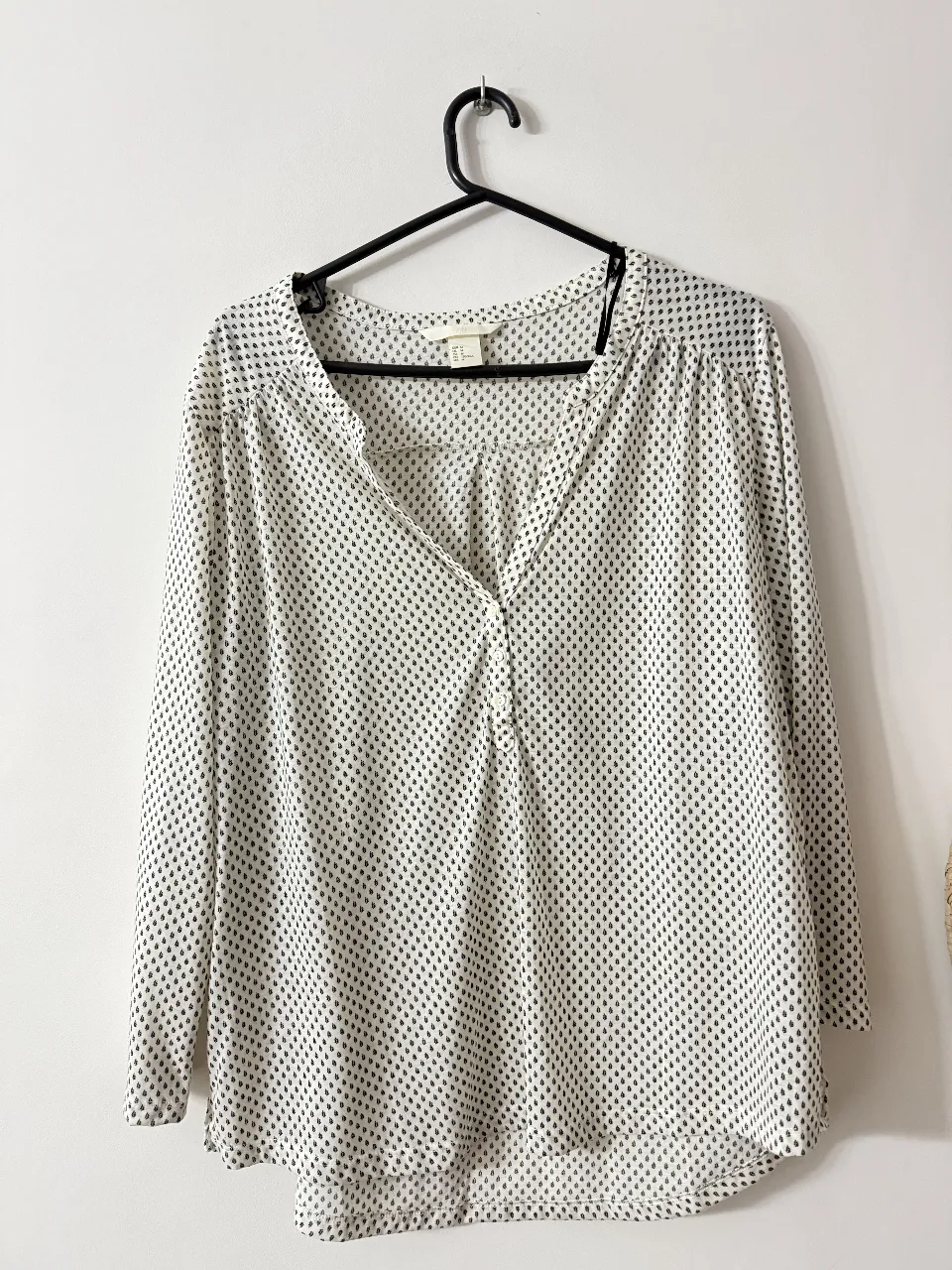 Blusa de mujer con estampado de hojas en blanco y negro. Cuello en V y mangas largas. Ideal para un look casual y elegante.