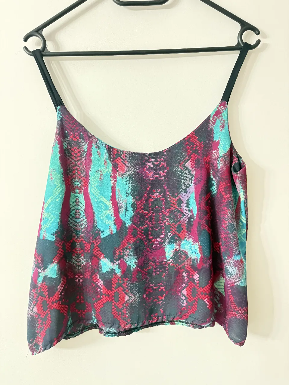 Top de mujer con estampado de serpiente en tonos turquesa, fucsia y negro. Ideal para un look moderno y audaz.