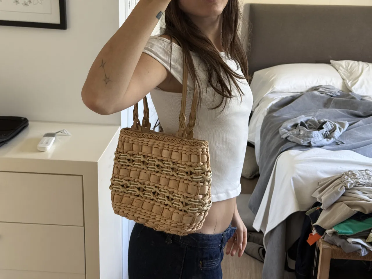 Cartera vintage tejida de paja con detalles en trencitas y tiras de cuero. Posee un compartimento principal con cierre y un bolsillo interno con cierre. Ideal para un look veraniego o ir a la playa.