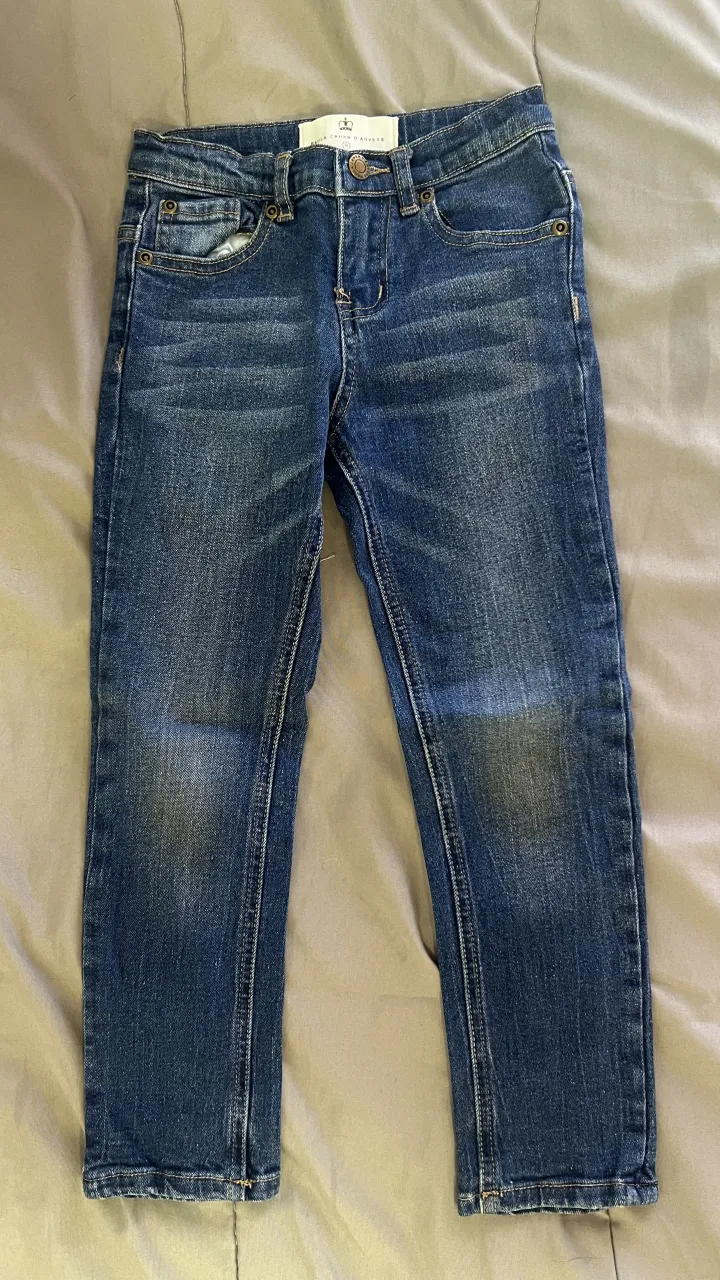 Jean de algodón azul con detalles de desgaste. Posee bolsillos delanteros y traseros.