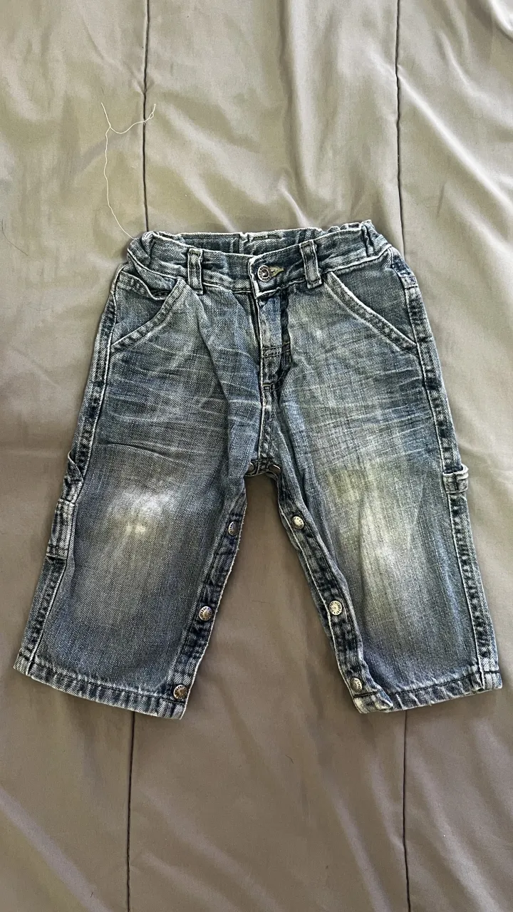 Shorts de jean para bebé, color azul desgastado. Posee detalles de roturas y botones en la parte inferior de las piernas.