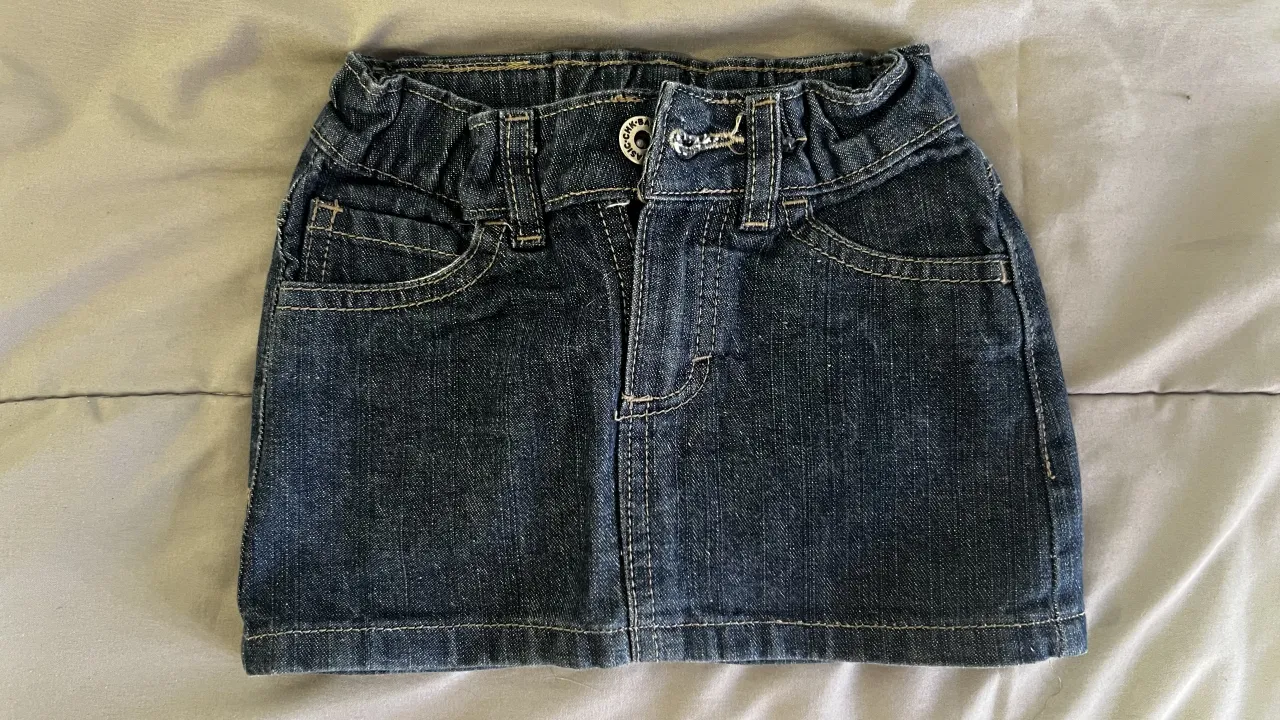 Pollera de jean azul oscuro con cintura elastizada y detalles de costura.