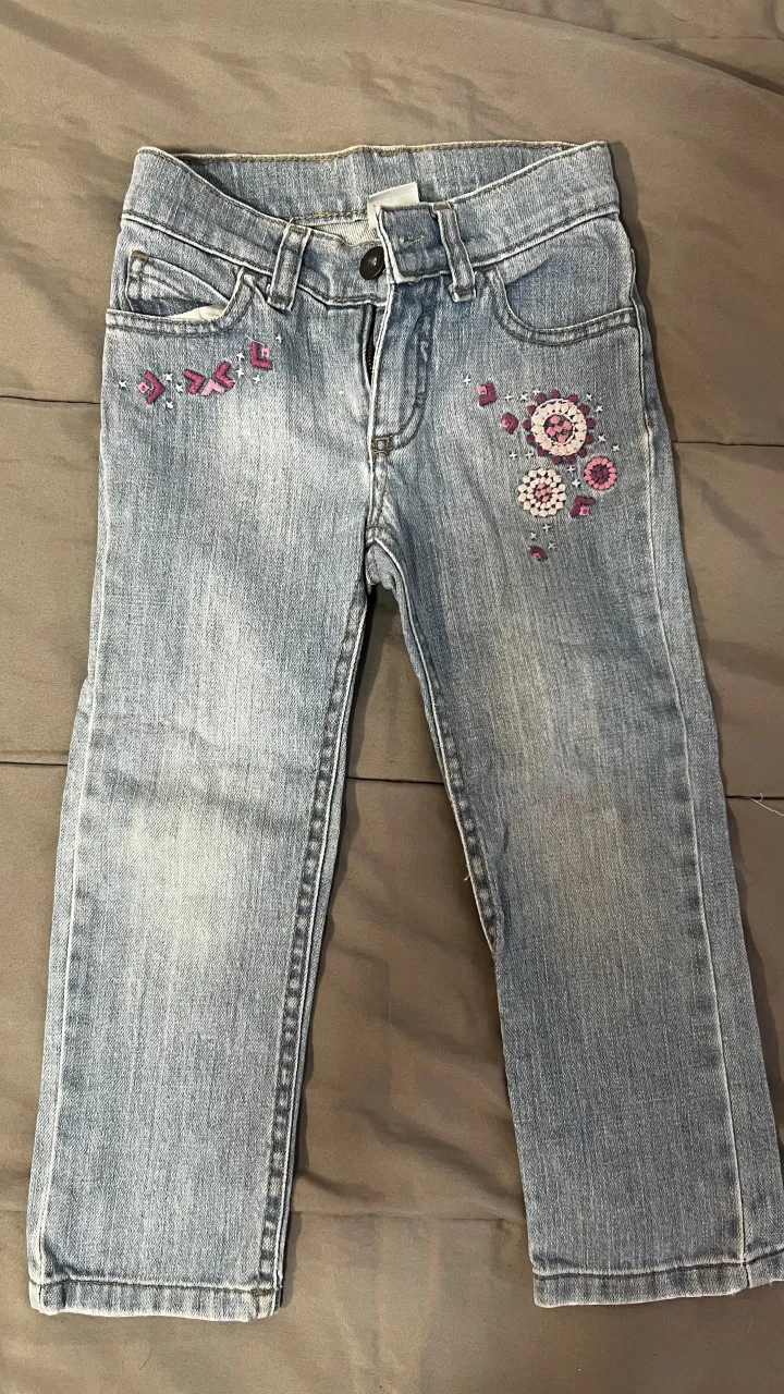 Jeans de algodón para niña con detalles bordados de flores y mariposas en la parte delantera. Lavado claro.