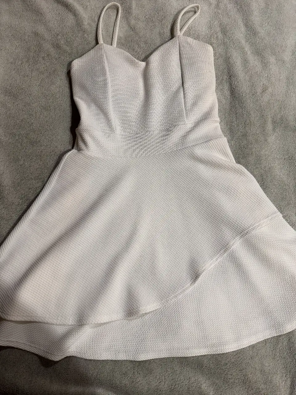 Vestido mini blanco con tiras finas y diseño drapeado. Ideal para eventos especiales o salidas nocturnas.